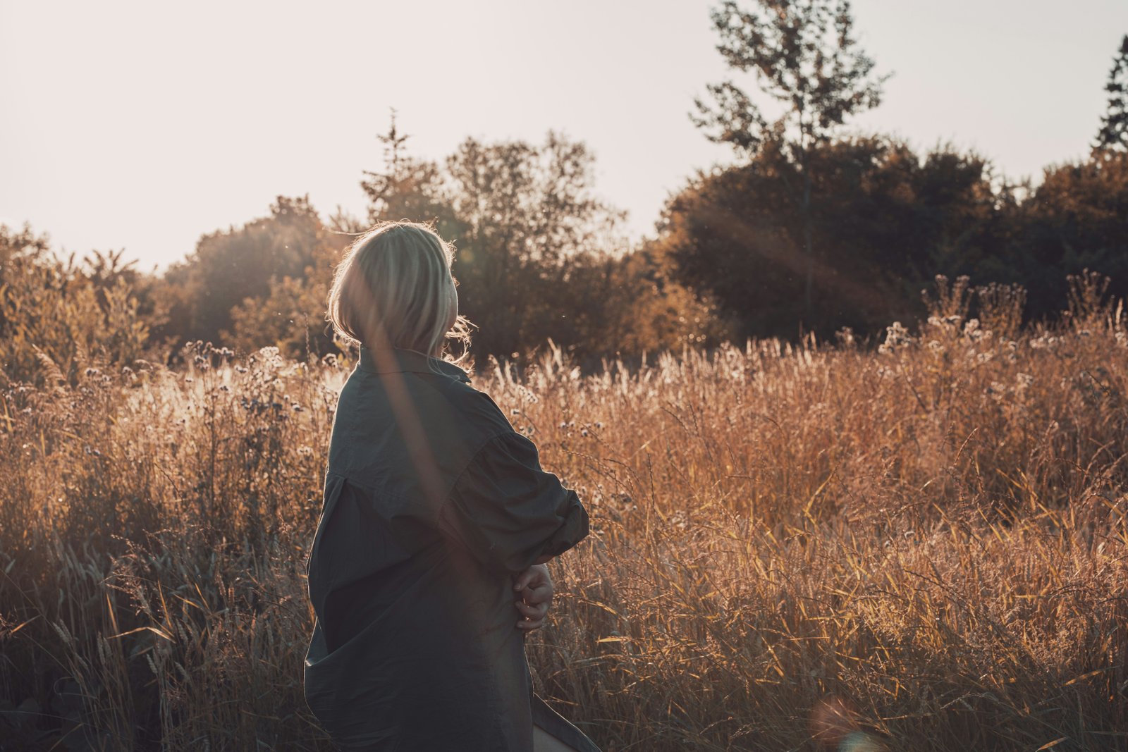 Hands raised in worship in warm autumn light